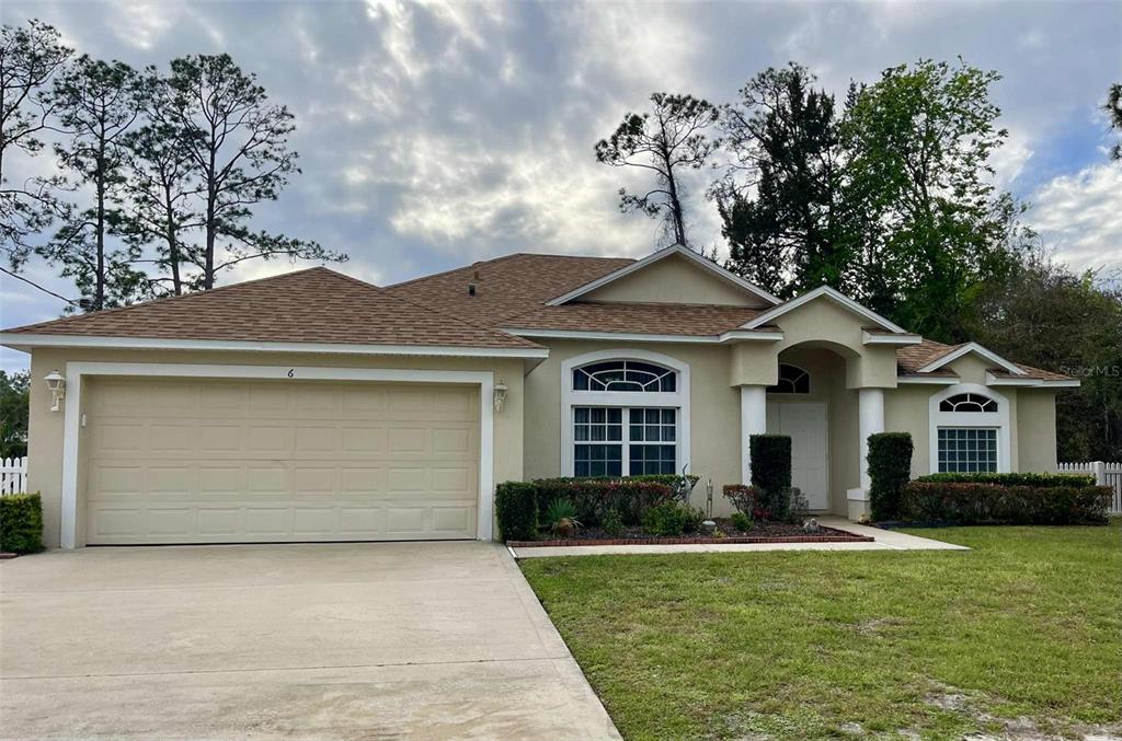 Undisclosed Address Palm Coast, FL 32164 - Photo 1 of 18 a front view of a house with a yard and garage