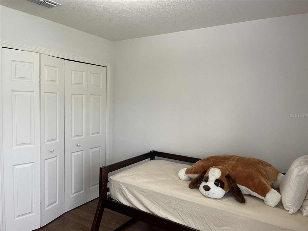 Undisclosed Address Palm Coast, FL 32164 - Photo 16 of 18 a bedroom with a bed and wooden floor