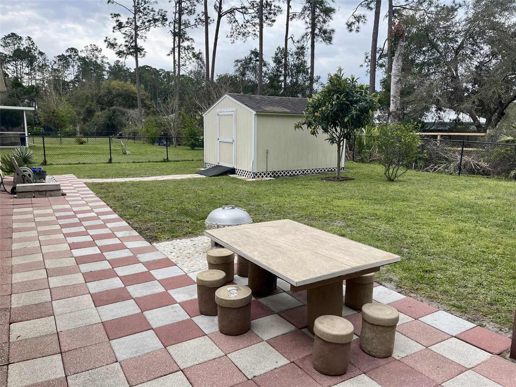 Undisclosed Address Palm Coast, FL 32164 - Photo 3 of 18 a view of a backyard with table and chairs potted plants and large tree
