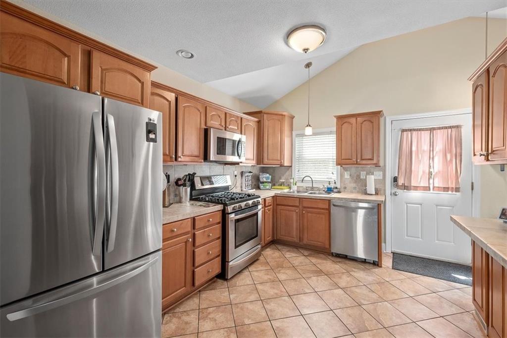 226 Bigham Street Pittsburgh, PA 15211 - Photo 11 of 25 a kitchen with granite countertop stainless steel appliances a refrigerator stove top oven and sink