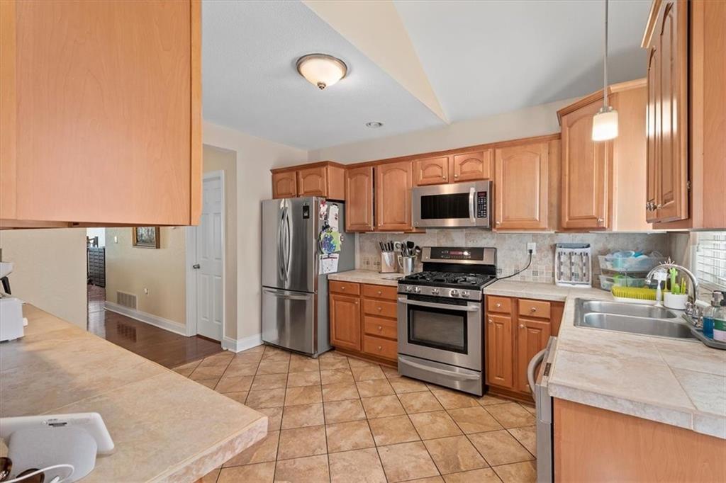 226 Bigham Street Pittsburgh, PA 15211 - Photo 12 of 25 a kitchen with stainless steel appliances granite countertop a refrigerator stove top oven and sink