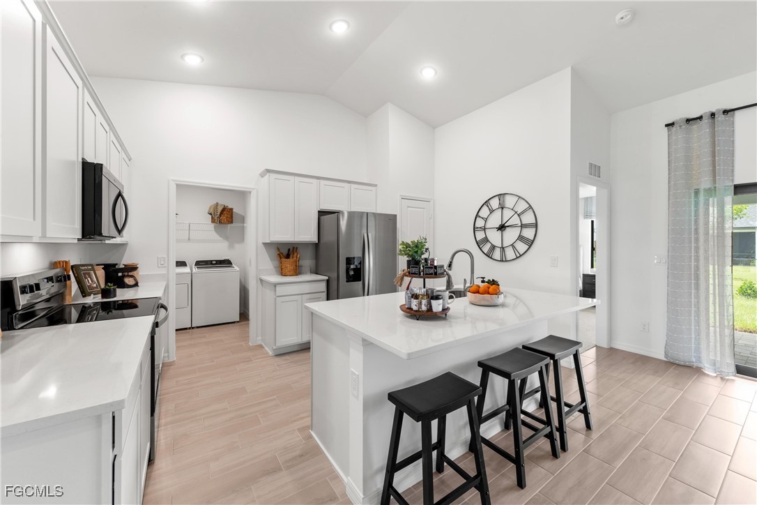 24 Southwest 15th Terrace Cape Coral, FL 33991 - Photo 4 of 14 a kitchen with stainless steel appliances a table chairs and a refrigerator