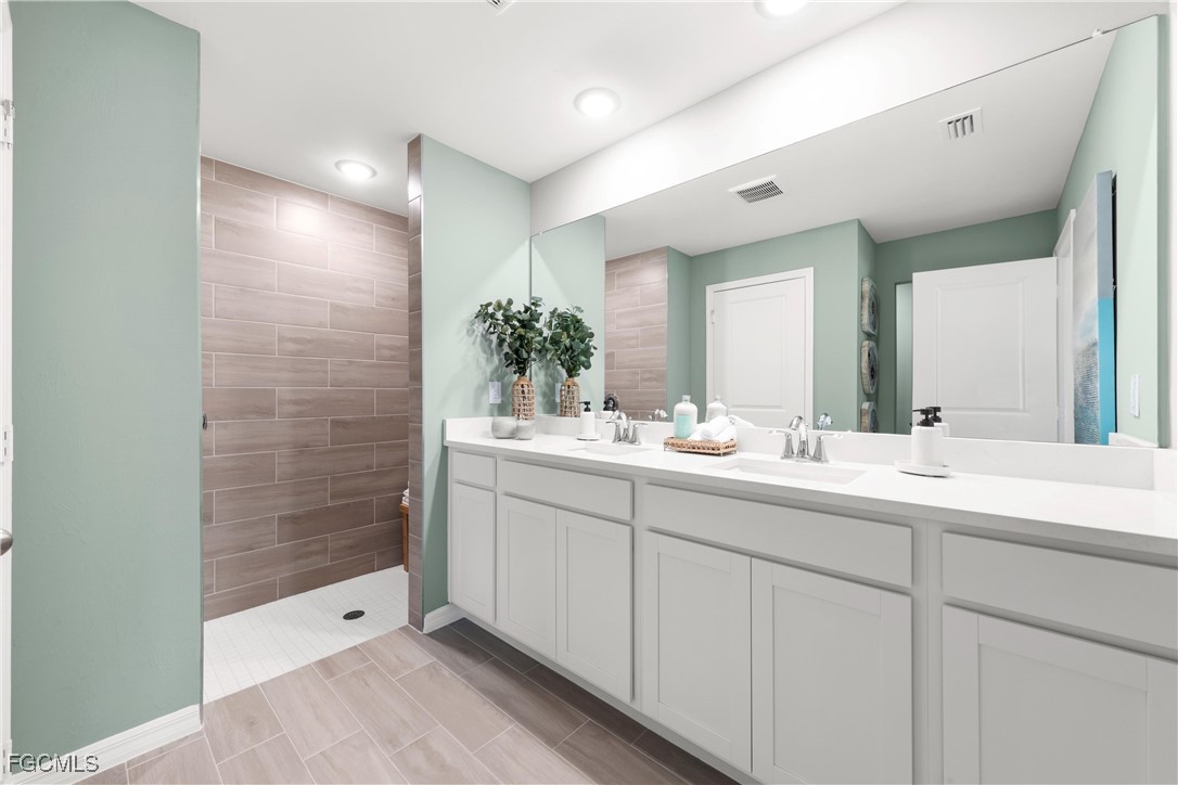 24 Southwest 15th Terrace Cape Coral, FL 33991 - Photo 10 of 14 a bathroom with a shower sink and mirror