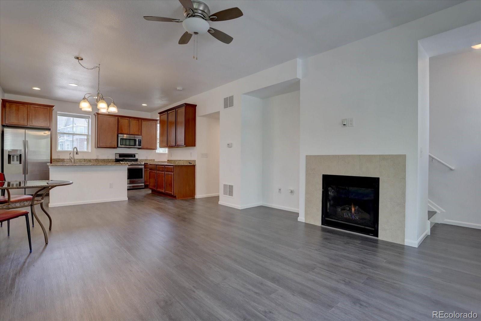 9520 Halstead Lane Lone Tree, CO 80124 - Photo 12 of 25 a view of a kitchen and dining room with wooden floor a fireplace