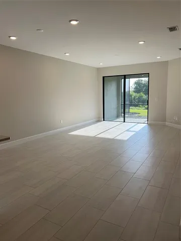 a view of an empty room with a fireplace and a window