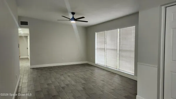 a view of an empty room with closet and a window