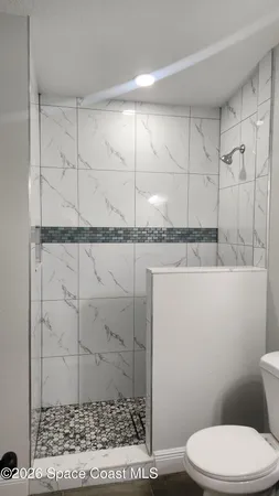 a bathroom with a toilet and a shower