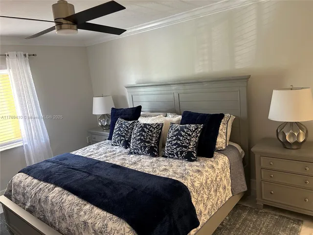 a large bed sitting in a bedroom next to a window and a lamp