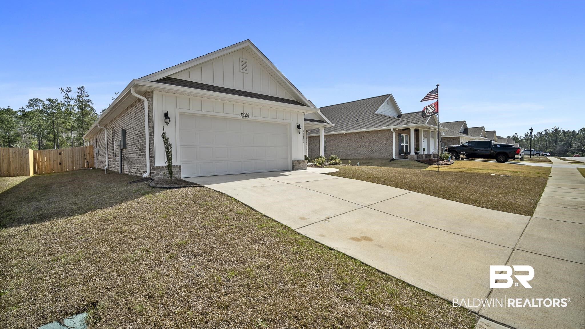 13887 Antler Hl Road Daphne, AL 36527 - Photo 28 of 50 View of front of property with board and batten siding, concrete driveway, a garage, a front lawn, and brick siding