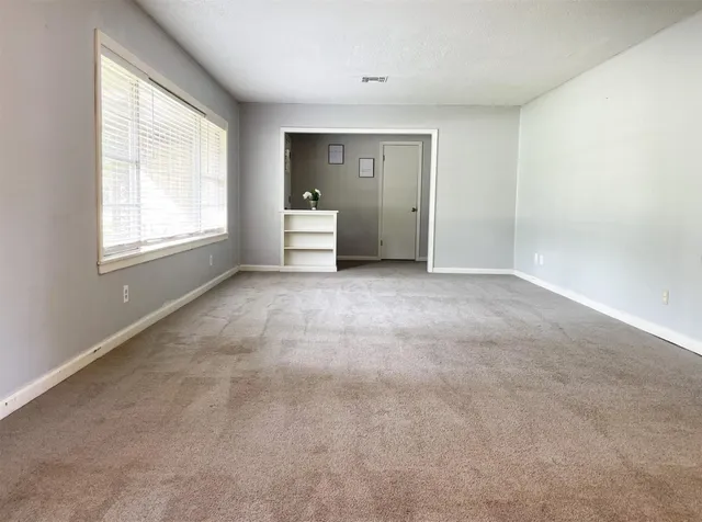 an empty room with windows and closet