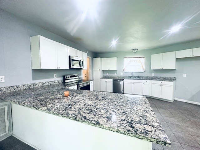 409 Koehl Street Wharton, TX 77488 - Photo 6 of 17 a large kitchen with granite countertop a counter top space cabinets and stainless steel appliances