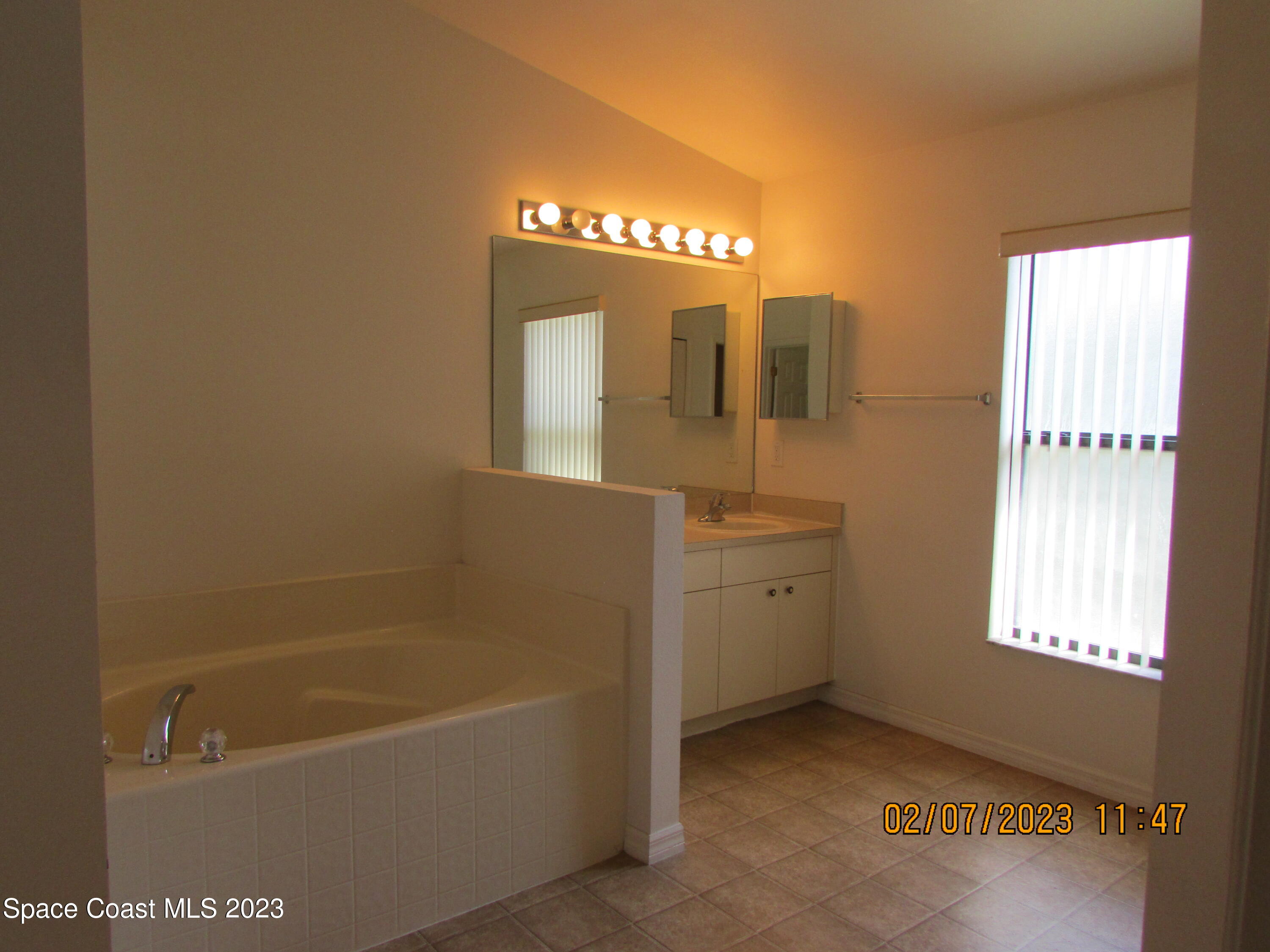 4001 Wilkes Drive Melbourne, FL 32901 - Photo 14 of 21 a bathroom with a tub a sink and a mirror
