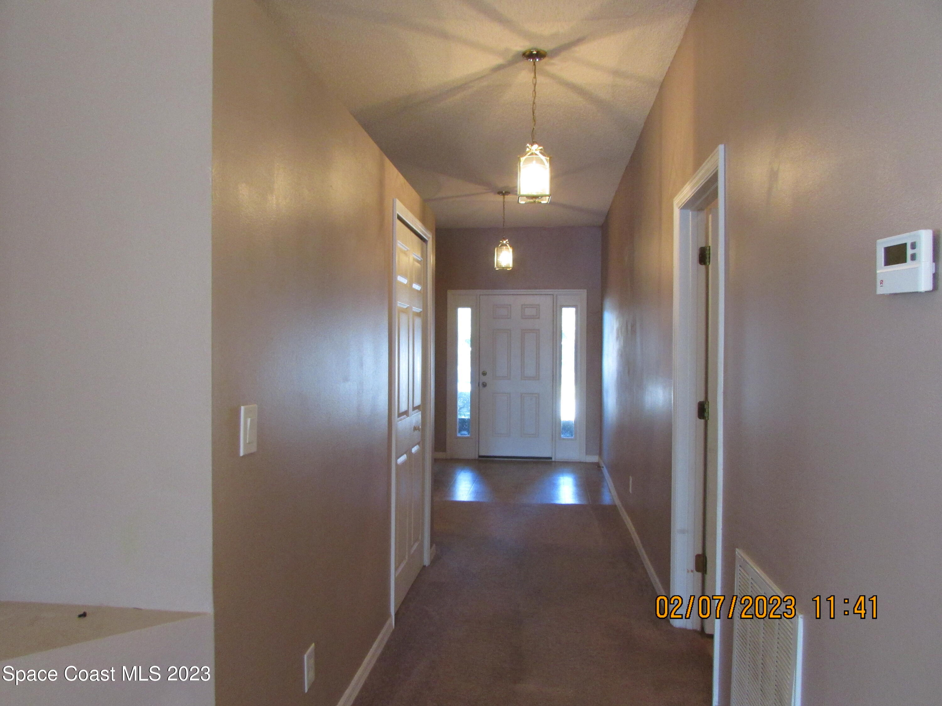 4001 Wilkes Drive Melbourne, FL 32901 - Photo 2 of 21 a view of a hallway with a chandelier fan and a livingroom view