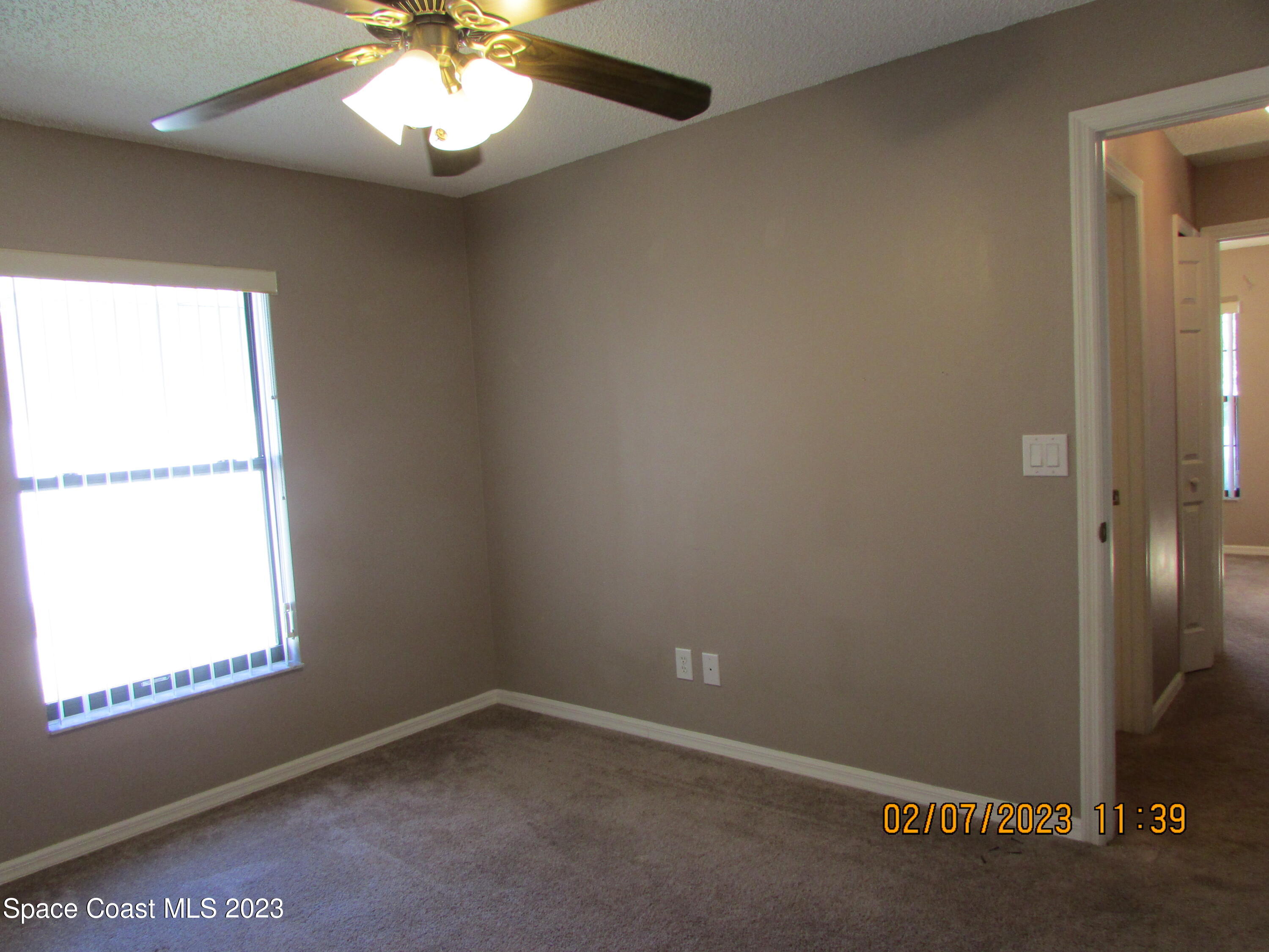 4001 Wilkes Drive Melbourne, FL 32901 - Photo 5 of 21 an empty room with a window and a fan
