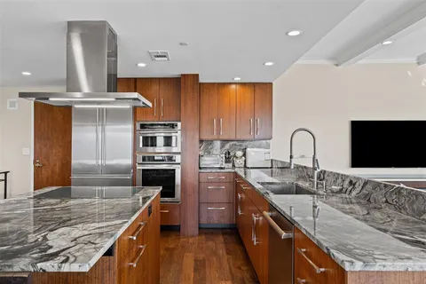 a kitchen with stainless steel appliances granite countertop a sink a stove and a refrigerator