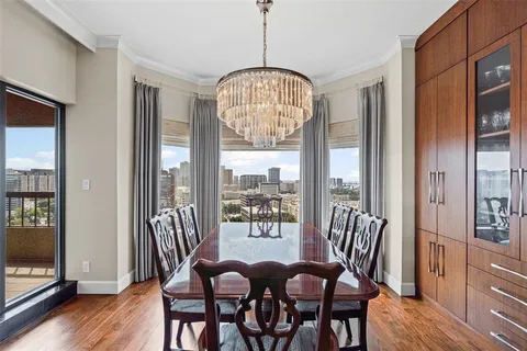 a dining room with furniture a chandelier and wooden floor