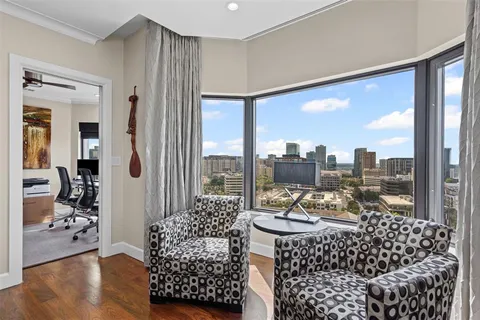 a living room with furniture and a floor to ceiling window