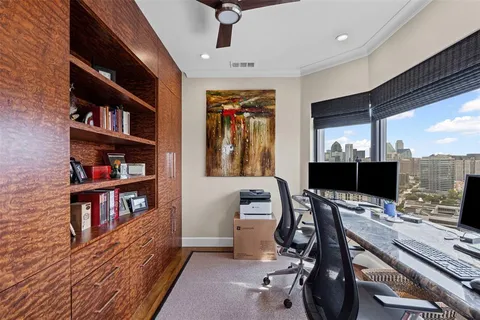 a view of a workspace with furniture and a book shelf