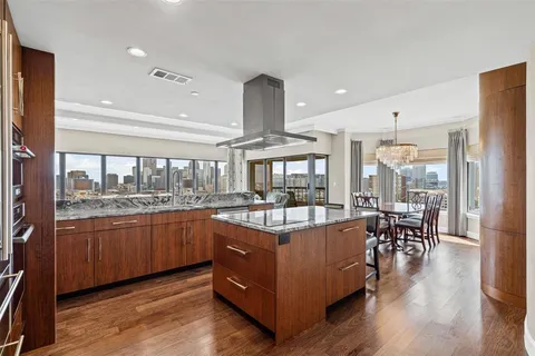 a living room with stainless steel appliances granite countertop furniture wooden floor and a view of kitchen