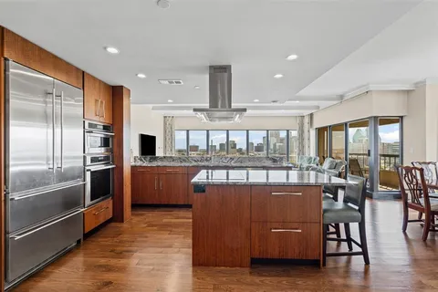 a view of a room with lots of wooden furniture and a large window