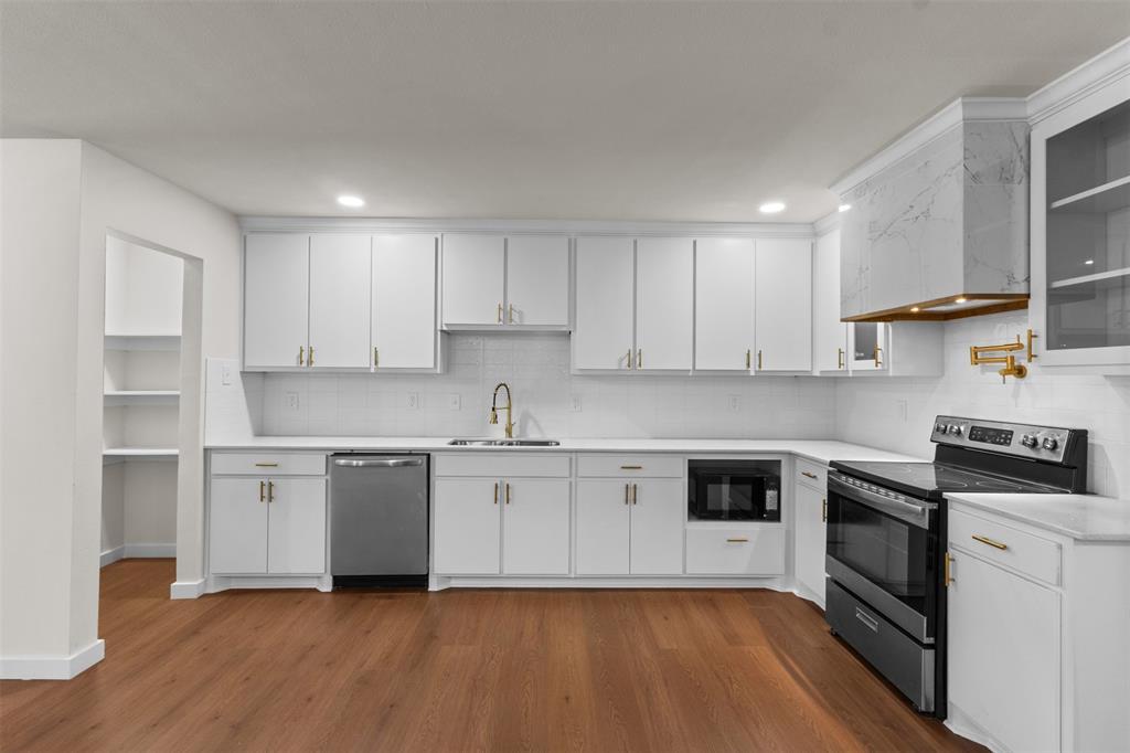 513 East Union Bower Road Irving, TX 75061 - Photo 10 of 34 White shaker-style cabinetry with gold-tone hardware, wood-finish flooring, undermount sink with a gold-tone faucet, integrated stainless steel dishwasher, and a built-in microwave