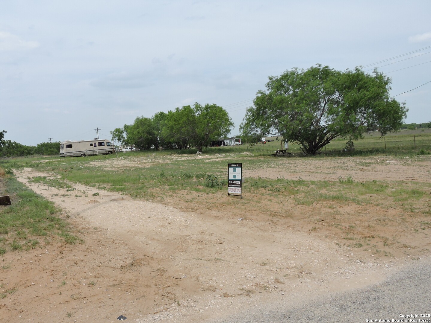 5968 Tabberer Road Poteet, TX 78065 - Photo 2 of 7 a view of a dry yard with trees
