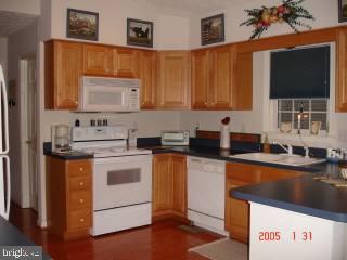 209 Windjammer Road Ocean Pines, MD 21811 - Photo 2 of 4 a kitchen with stainless steel appliances a stove microwave and cabinets