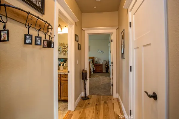 a bedroom with a bed and a lamp on dresser next to a window