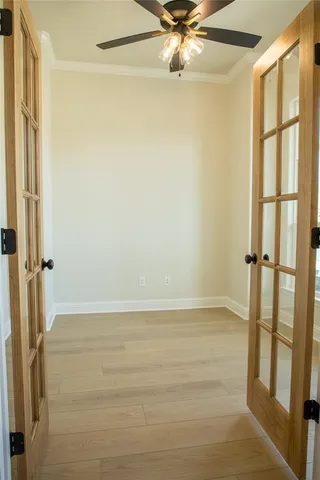 an empty room with kitchen view and fireplace