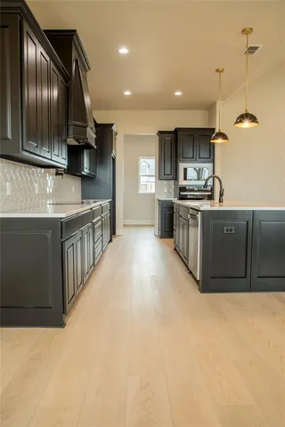 a kitchen with granite countertop cabinets sink and wooden floor