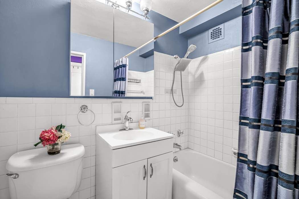 11 Riverside Drive, Unit 5PW Manhattan, NY 10023 - Photo 6 of 10 a bathroom with a sink vanity mirror and tub