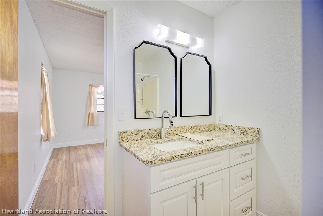 2052 West Stryker Road Avon Park, FL 33825 - Photo 25 of 45 a bathroom with a granite countertop sink and a mirror