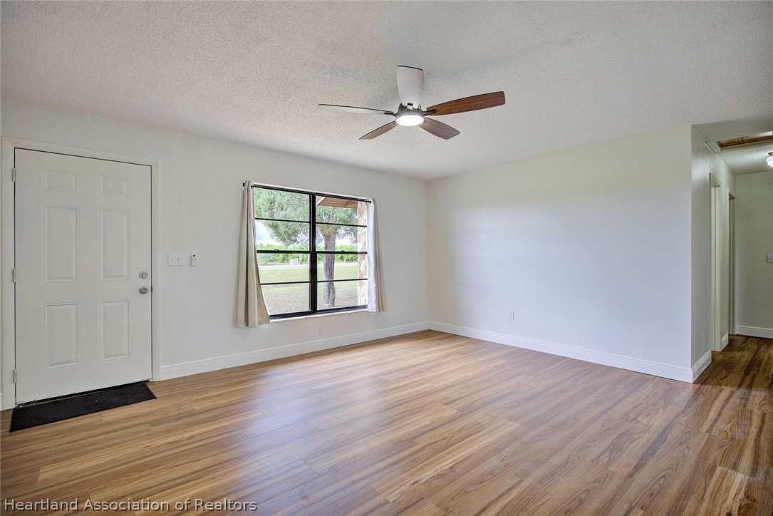 2052 West Stryker Road Avon Park, FL 33825 - Photo 5 of 45 an empty room with wooden floor fan and windows