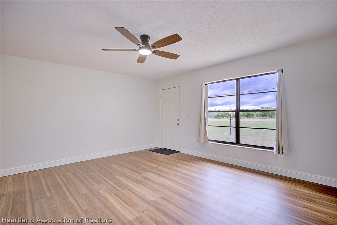 2052 West Stryker Road Avon Park, FL 33825 - Photo 8 of 45 a view of an empty room with a window and wooden floor