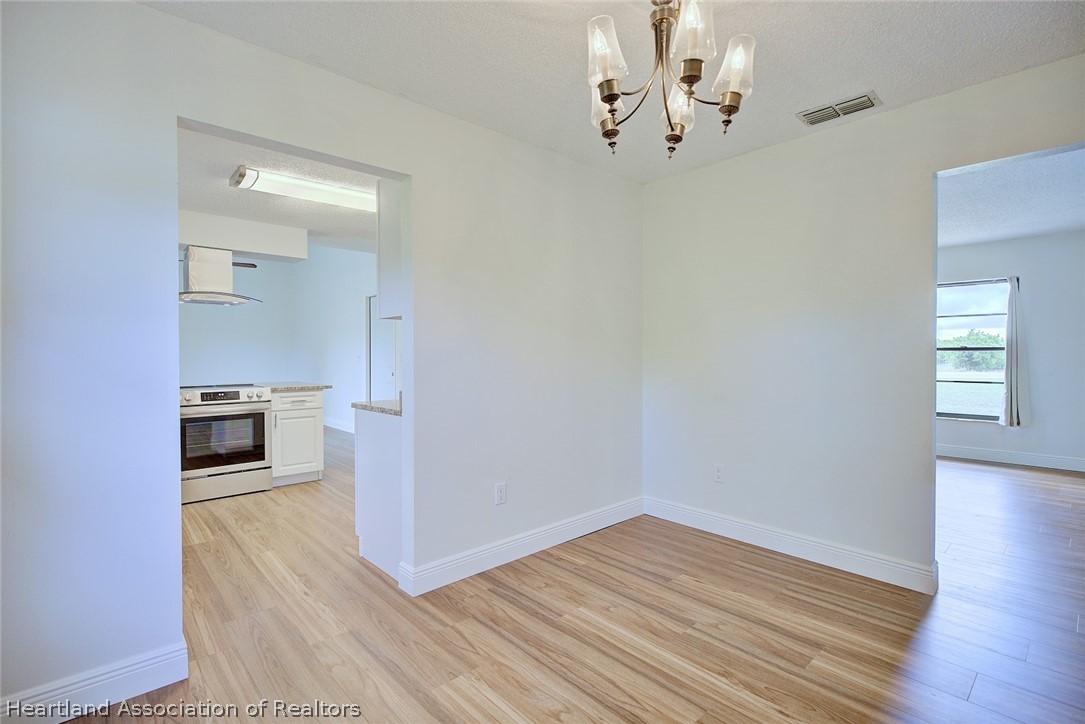 2052 West Stryker Road Avon Park, FL 33825 - Photo 10 of 45 wooden floor in an empty room with a window