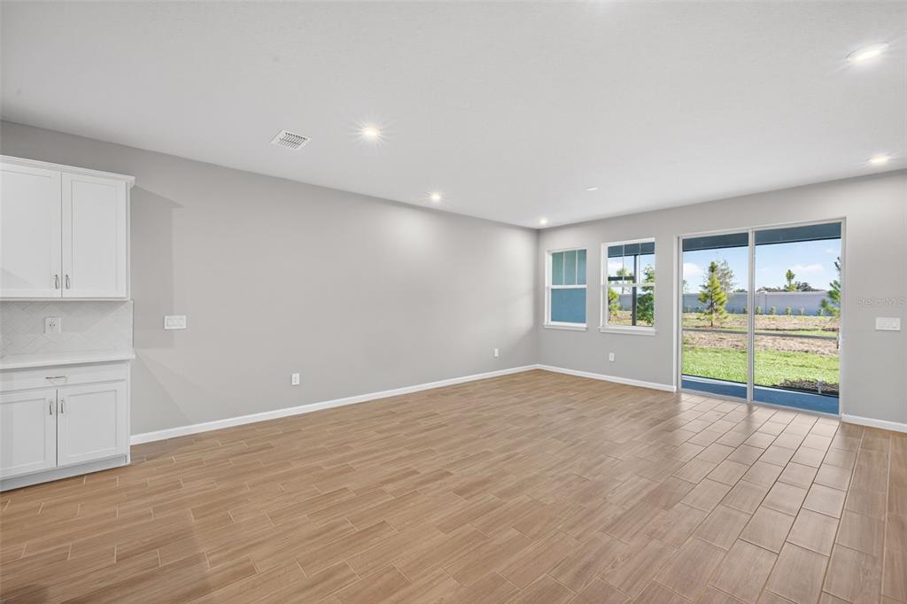 8822 Ginko Run Parrish, FL 34219 - Photo 13 of 30 a view of an empty room with a window and wooden floor