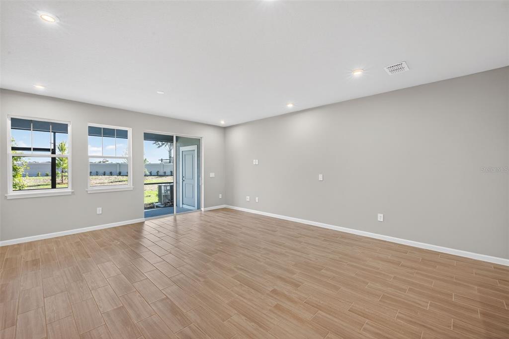 8822 Ginko Run Parrish, FL 34219 - Photo 14 of 30 a view of an empty room with a window and wooden floor