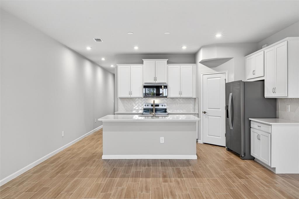 8822 Ginko Run Parrish, FL 34219 - Photo 10 of 30 a view of kitchen with granite countertop cabinets and refrigerator