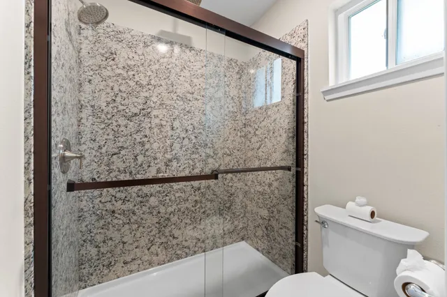 a bathroom with a toilet and a shower