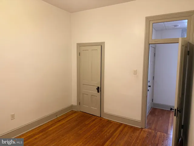 an empty room with wooden floor and closet