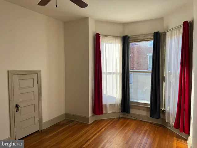a view of a room with wooden floor and windows