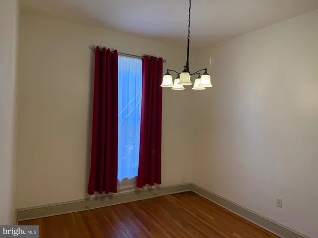 a view of a room with a window and wooden floor