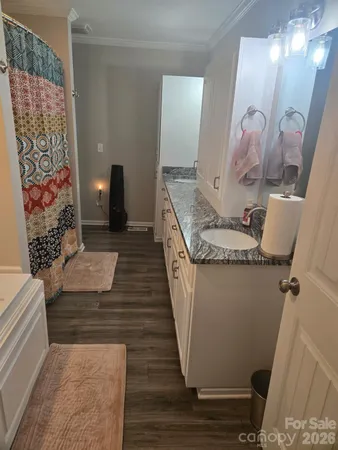 a hallway with painting on the wall and shower