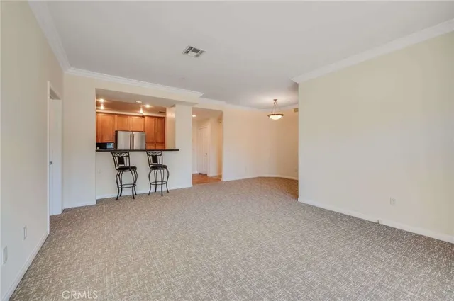 a view of an empty room with furniture and a window
