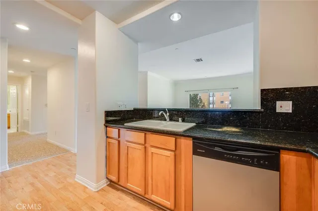 a kitchen with stainless steel appliances granite countertop a sink and a stove