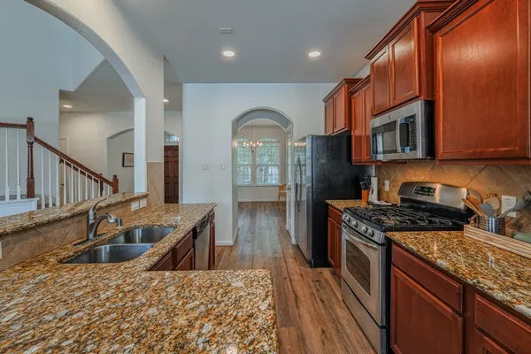 a kitchen with stainless steel appliances granite countertop a stove a sink and a microwave