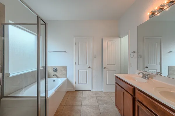 a spacious bathroom with a shower sink and mirror