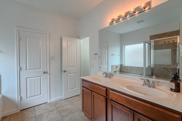 a bathroom with a double vanity sink and a mirror