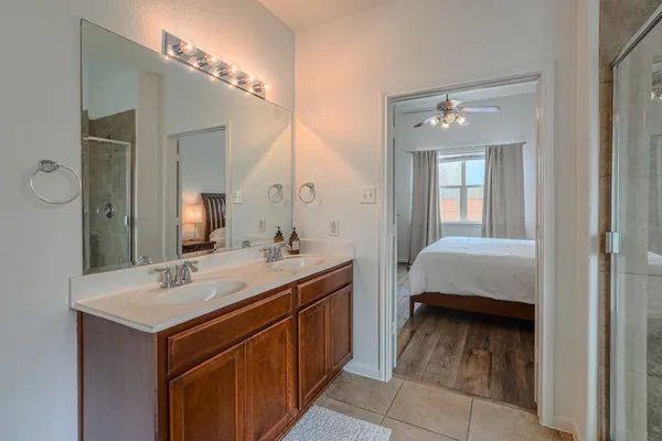 a en suite bathroom with a double vanity sink and a mirror
