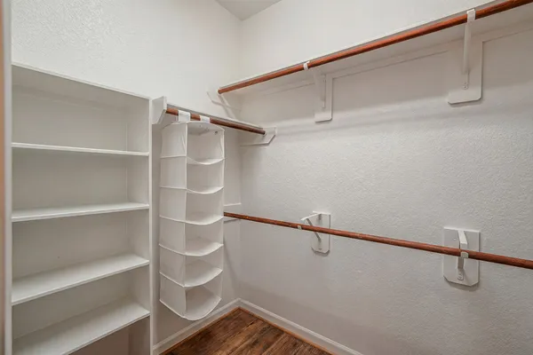 a view of walk in closet with empty racks